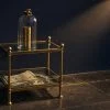 Two-tier brass and glass display structure with locked dome on top and open tray below, illustrating NPS Tier 1 vs Tier 2 contrast